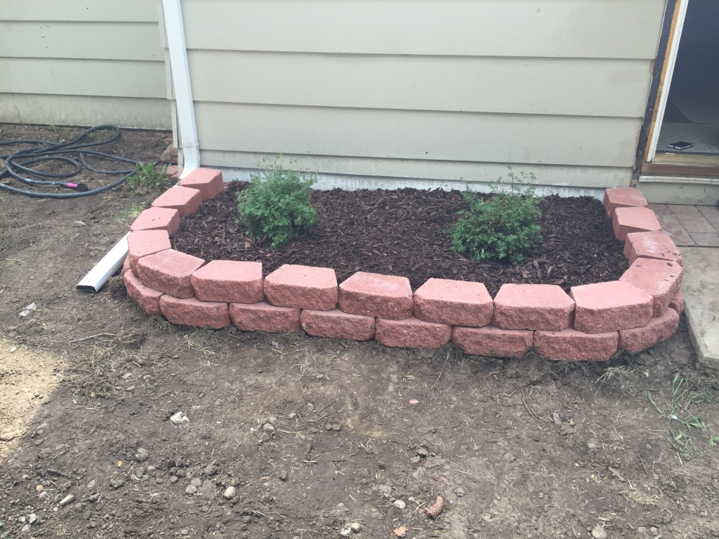 Raised planter bricks, mulch and bushes